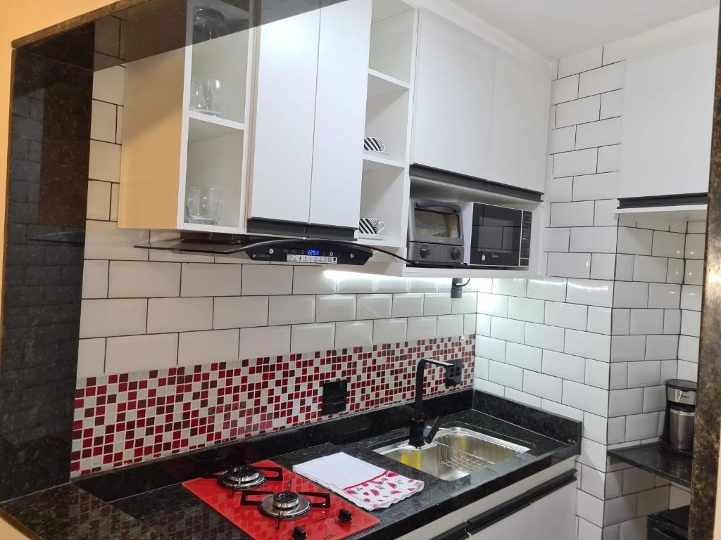 a kitchen with white cabinets and a sink at Apartamento na Barra da Tijuca in Rio de Janeiro