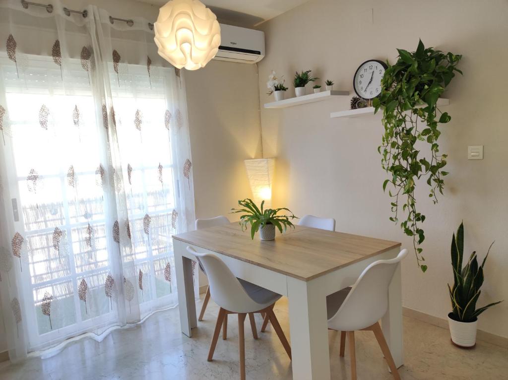 a dining room with a table and chairs and a clock at Entre la Alhambra y Sierra Nevada in Cenes de la Vega
