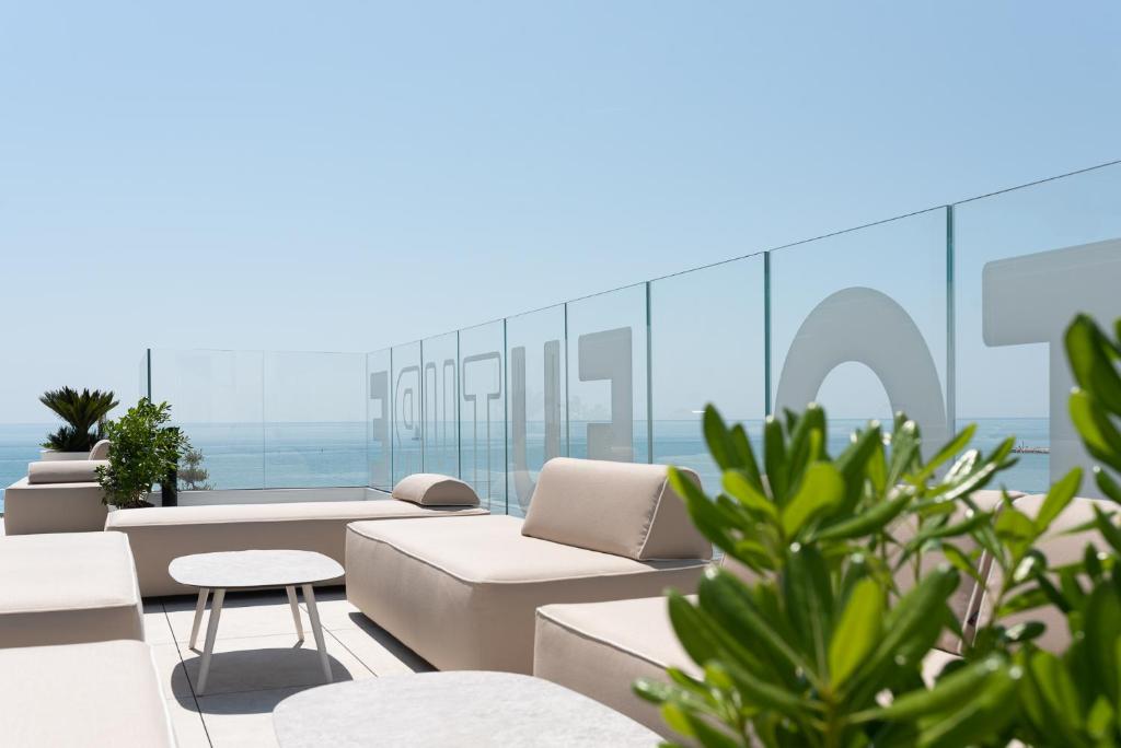 a balcony with couches and chairs and plants at Unico Hotel Caorle in Caorle