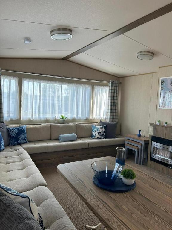 a living room with a couch and a table at Tarka Holiday Park - Summer Breeze - Coastal Breaks - North Devon - Braunton-Barnstaple in Ashford