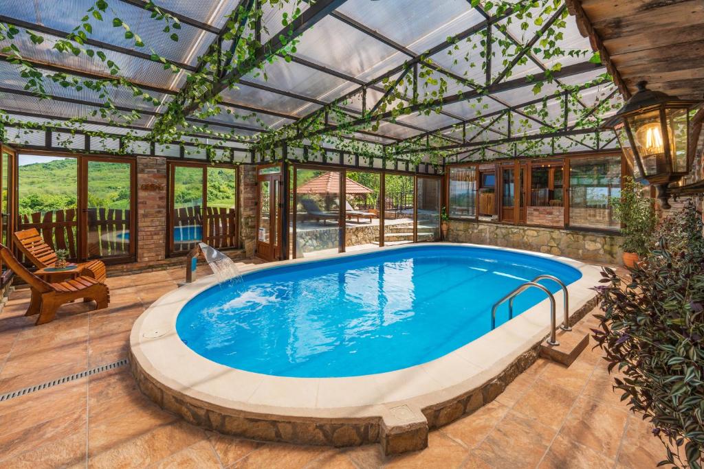 uma piscina interior numa casa com tecto de vidro em Etno Vila Kula em Malo Središte