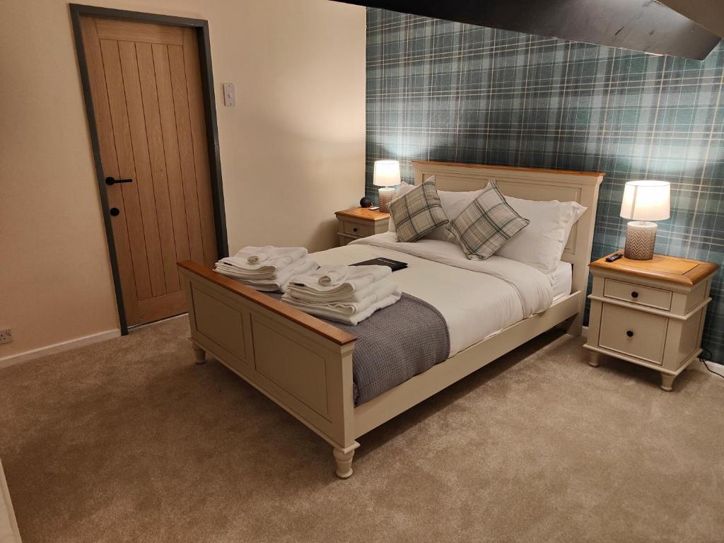 a bedroom with a bed with two night stands and two lamps at Ystafell Gelert Room in Beddgelert