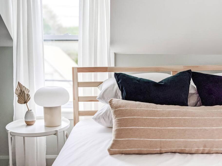 1 dormitorio con cama con almohadas y ventana en Scandi Inspired 2 Bed Suite Sandbanks Pass Incl, en Picton