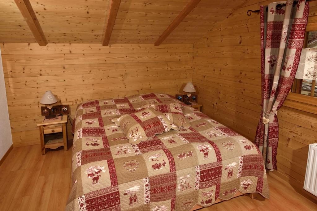 a bedroom with a bed in a log cabin at Hotel Les Mélèzes in Haudères