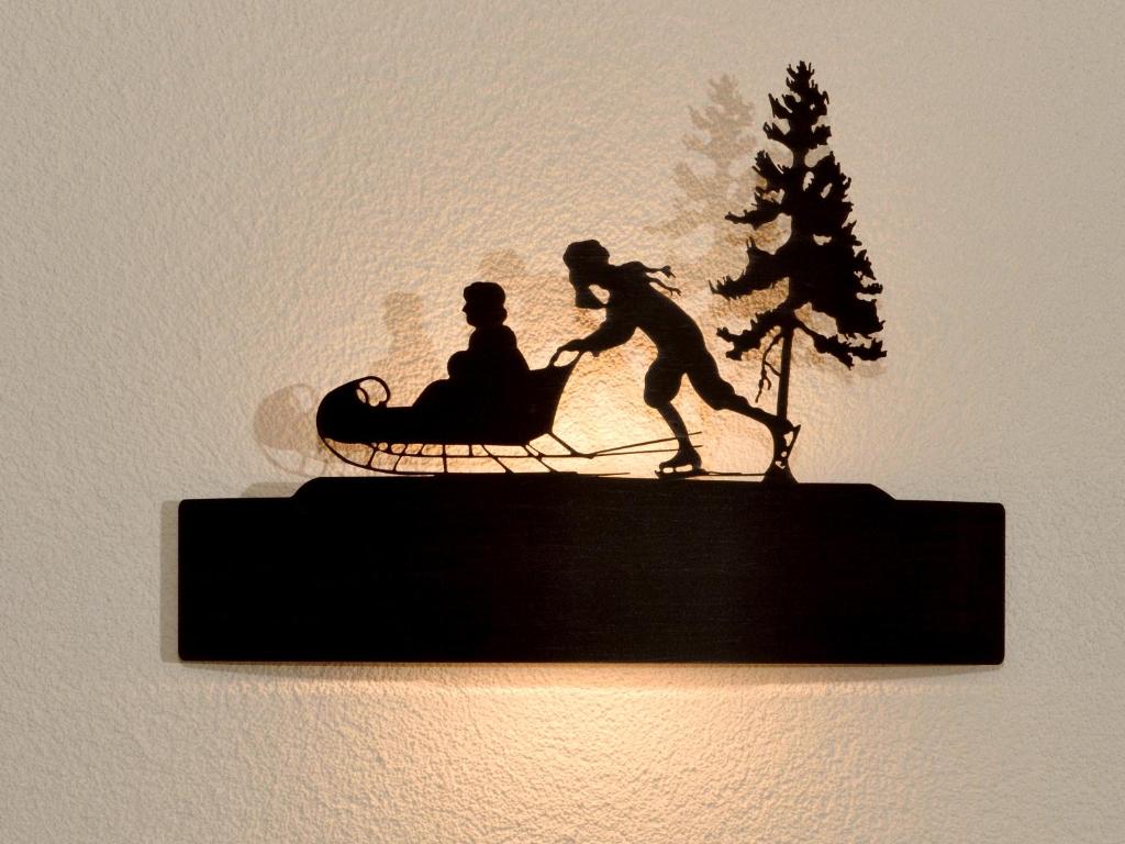 a statue of a man pulling a woman in a sleigh at Hotel Les Mélèzes in Haudères