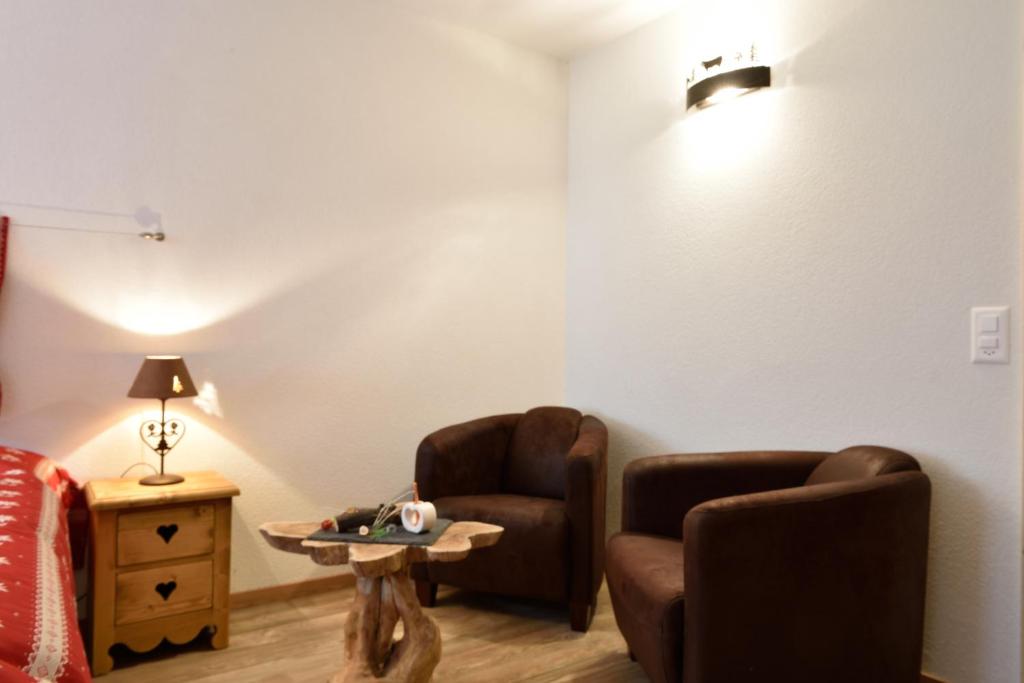 a living room with two chairs and a table at Hotel Les Mélèzes in Haudères