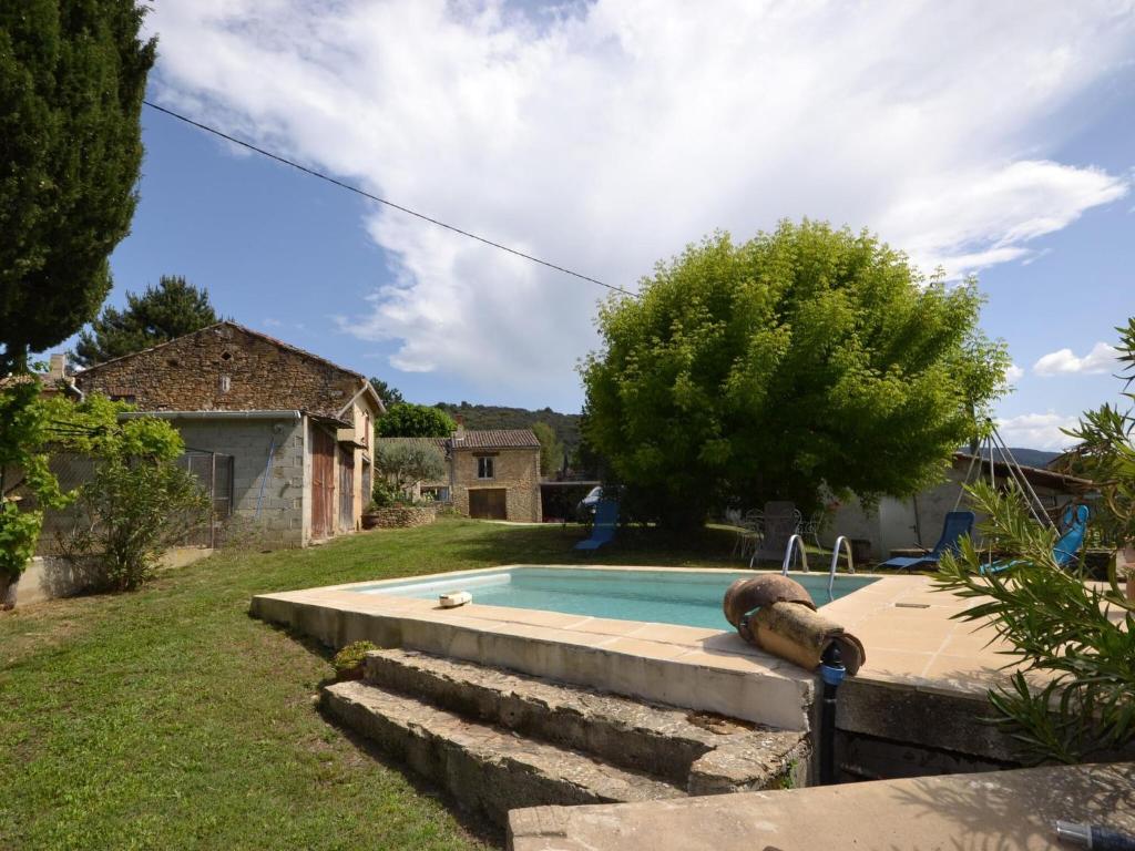 a backyard with a swimming pool and a house at Flat with private pool in the heart of nature in Malaucène