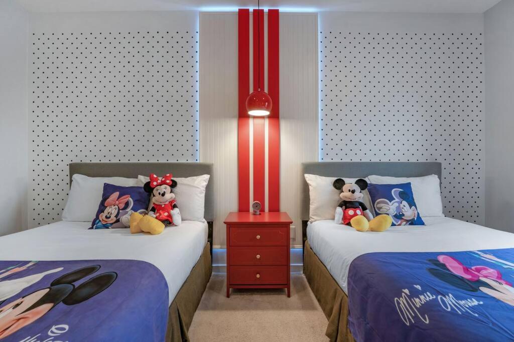 two beds with stuffed animals on them in a room at Find your Cozy home 8 minutes near Disney and Universal in Orlando
