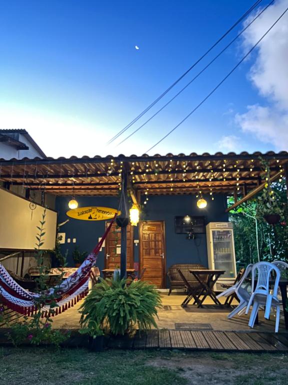 um pátio com cadeiras e uma rede de descanso numa casa em Estação Noronha Hostel em Fernando de Noronha