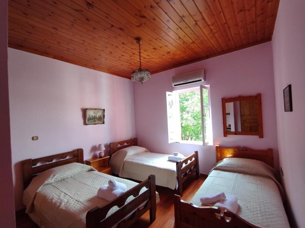 um quarto com duas camas e uma janela em Othon's Guest House em Hidra