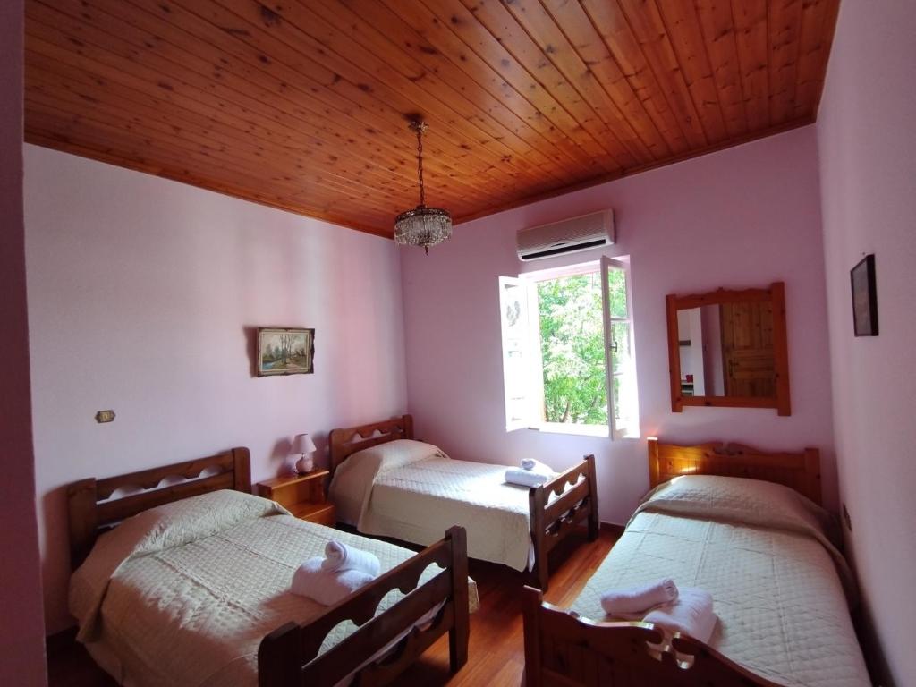 a room with two beds and a window at Othon's Guest House in Hydra