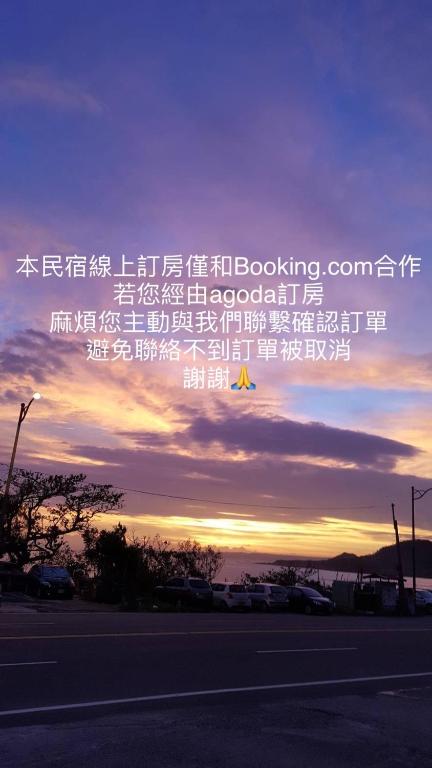 a writing in the sky with the sunset in the background at 岸戀民宿 墾丁船帆石 in Eluan