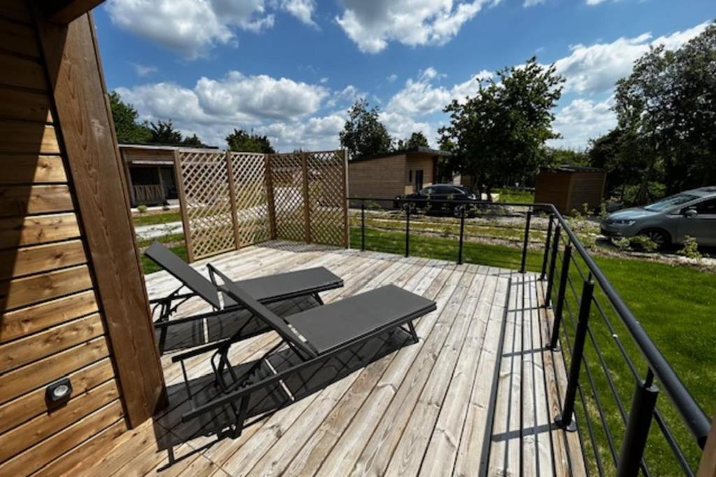 een houten terras met een tafel en stoelen erop bij Cottage - 40 m all comfort with garden in Guérande