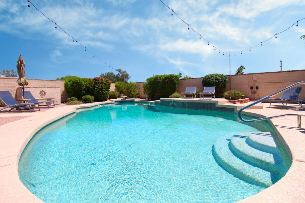 een groot zwembad met blauw water in een tuin bij Luxurious Scottsdale Guesthouse by the Pool in Phoenix