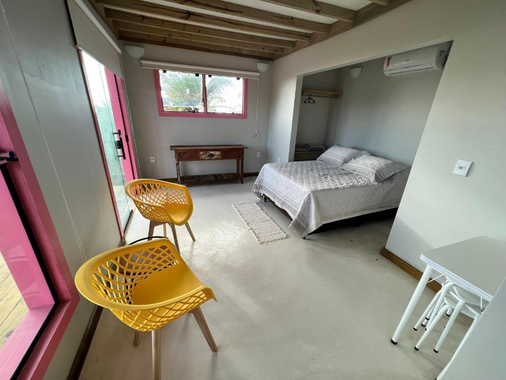 1 dormitorio con 1 cama, mesa y sillas en EcoFlats Caraiva en Caraíva