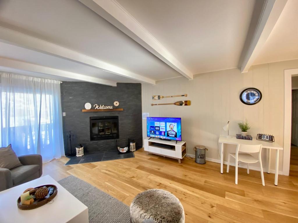 uma sala de estar com um sofá e uma televisão em Mountain view fully renovated 6-8 people condo em Mont-Tremblant