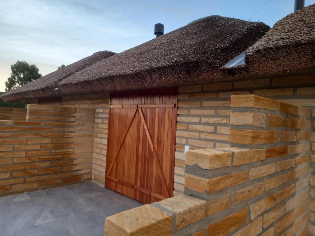 un edificio de ladrillo con puerta de garaje de madera en KARAPOTÓ parador rural, en Cambará