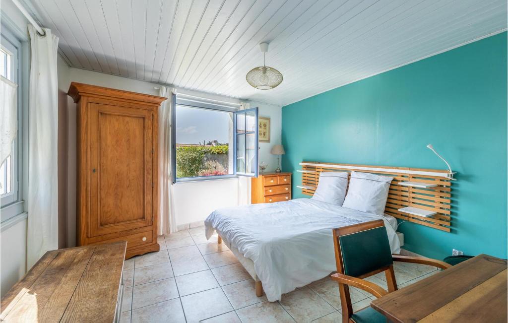 Dormitorio azul con cama y ventana en Awesome Home In Noirmoutier En Lile With Kitchen, en Noirmoutier-en-l'Île