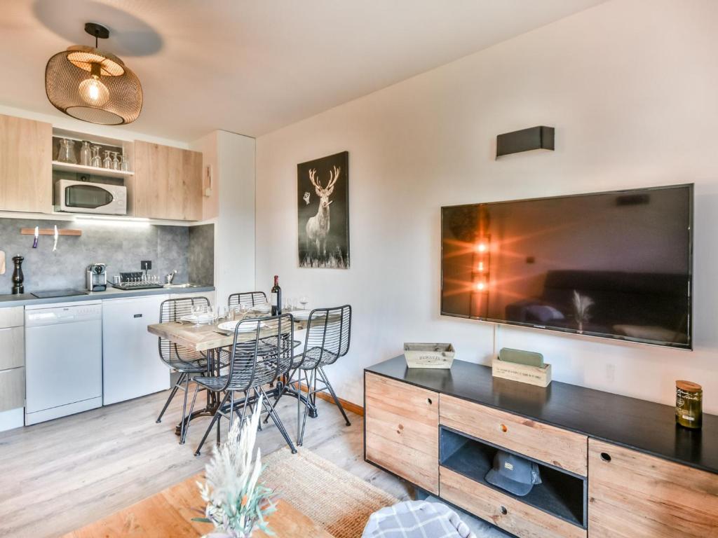 une cuisine et une salle à manger avec une table et une grande télévision dans l'établissement Appart rénové 4 pers, centre Les Gets, proche remontées, balcon, parking - FR-1-685-70, aux Gets