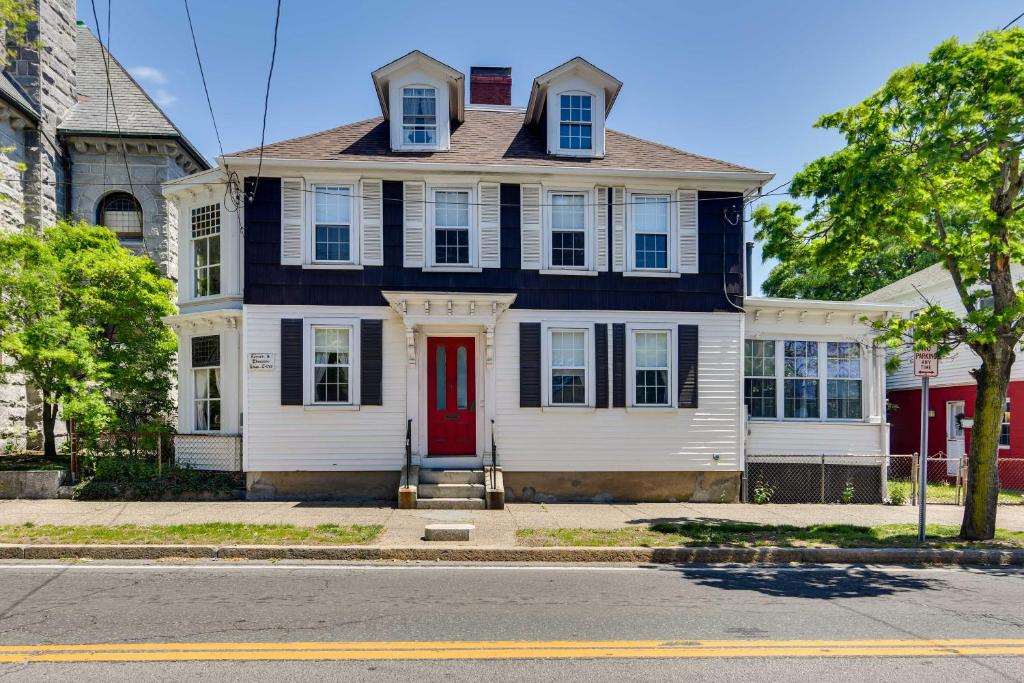 une maison blanche avec une porte rouge dans une rue dans l'établissement Historic Warren Vacation Rental Walk to Beaches!, à Warren