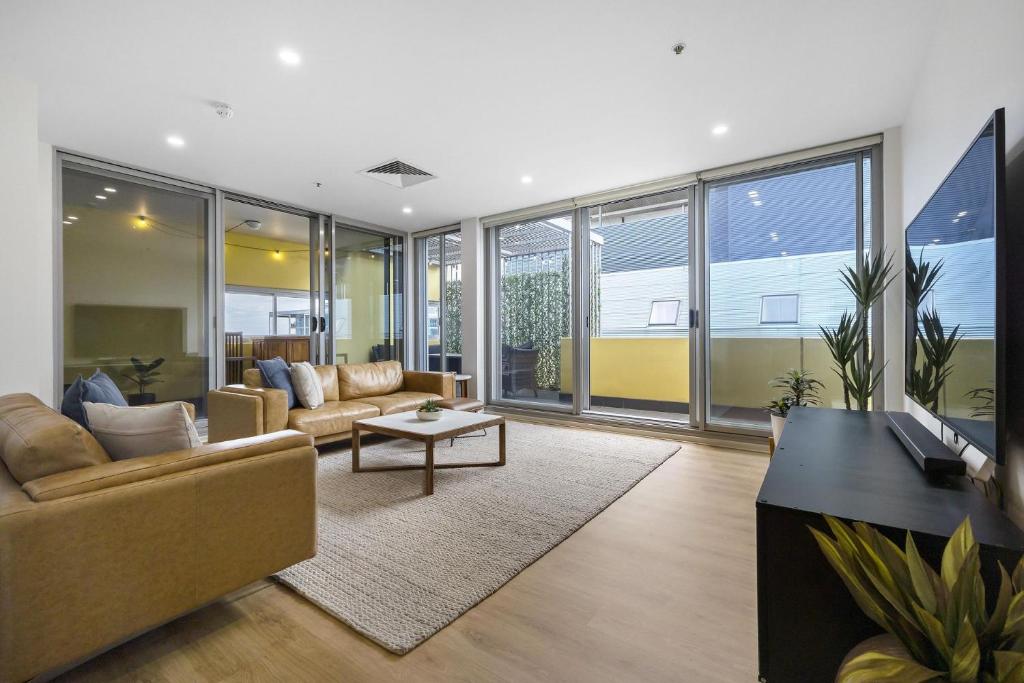 a living room with a couch and a table at Meadow - The York Skyline Apartment in Adelaide