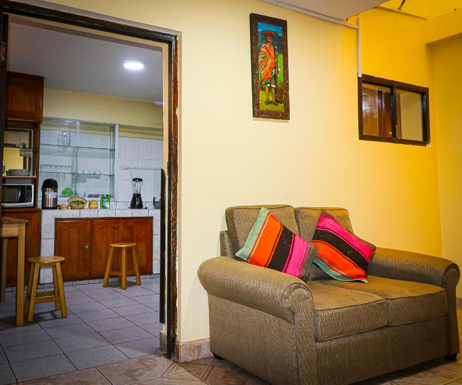 un soggiorno con divano e cucina di Cusco Hawka Pacha hostal a Cuzco
