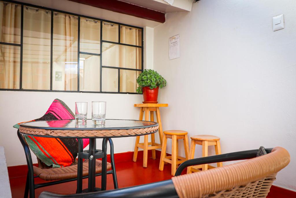 tavolo e sedie in una stanza con finestra di Cusco Hawka Pacha hostal a Cuzco