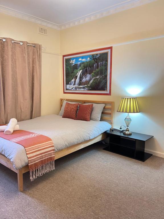 a bedroom with two beds and a picture on the wall at Werribee DGH Accommodation in Werribee