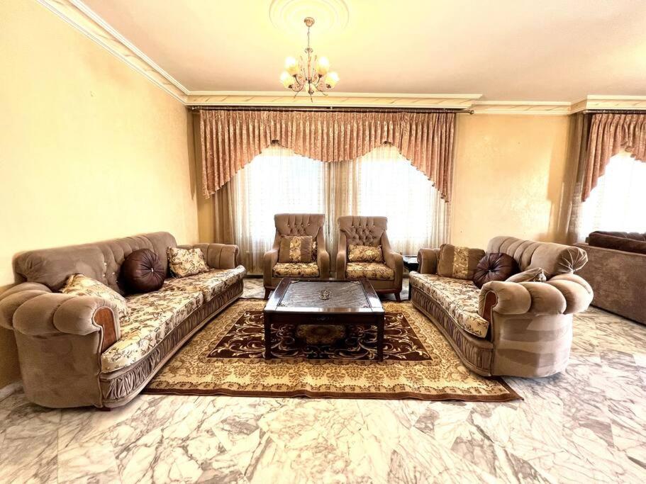 ein großes Wohnzimmer mit Sofas und einem Couchtisch in der Unterkunft Cozy 3 Bedroom Apartment Near 7th Circle in Amman