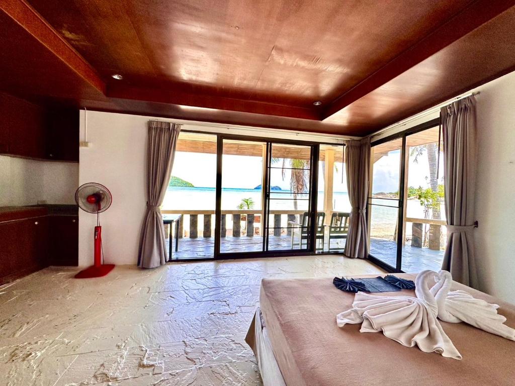 a bedroom with a bed and a large window at Beck's Resort in Haad Pleayleam