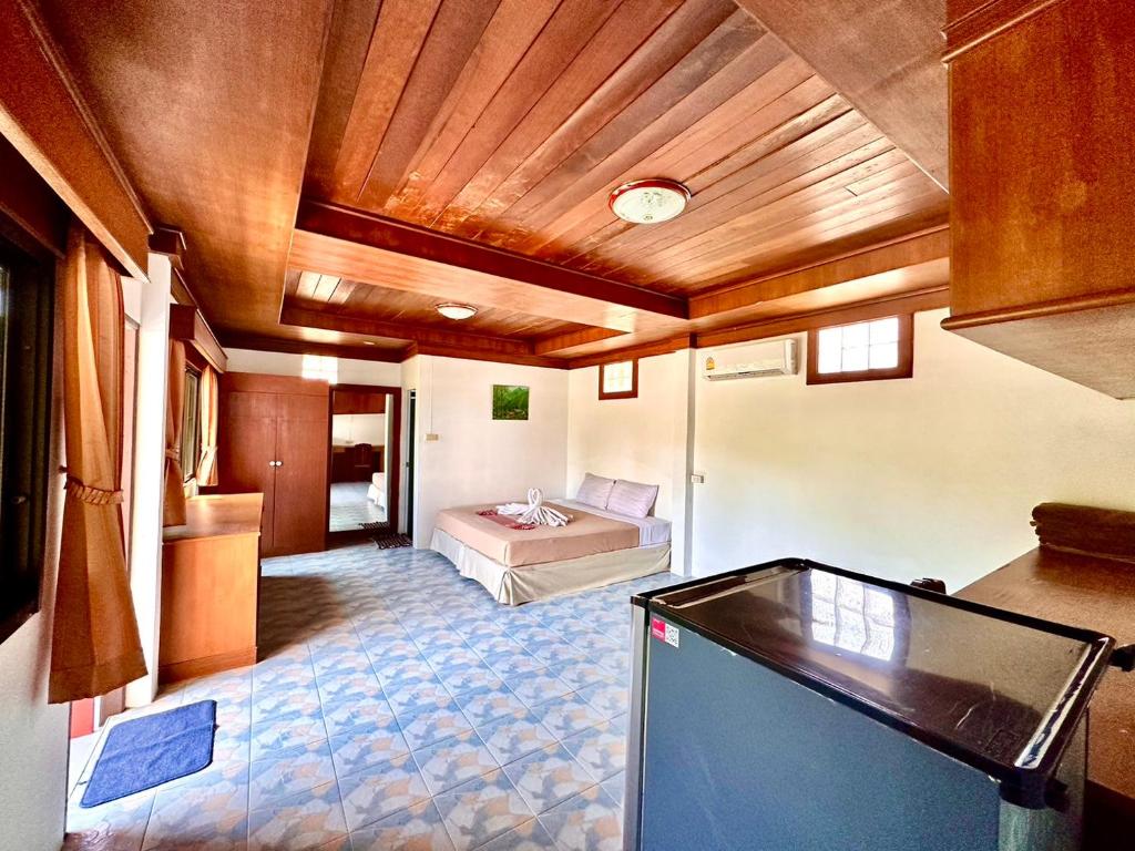 a room with a bed and a television in it at Beck's Resort in Haad Pleayleam