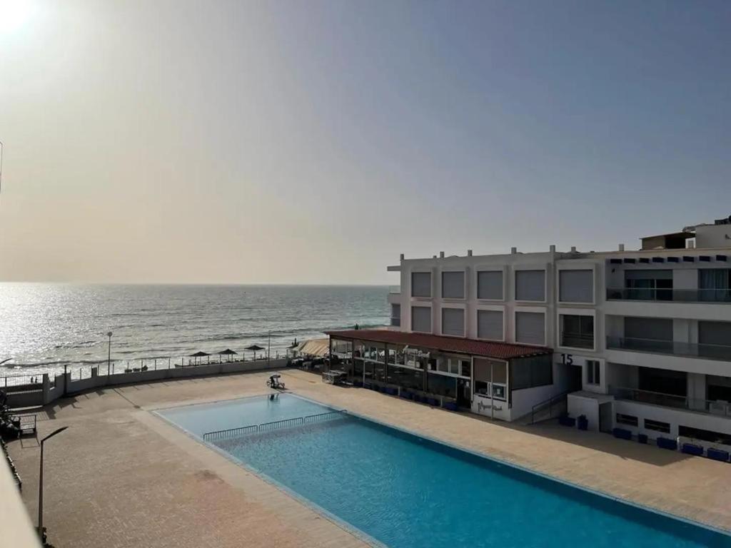 ein Hotel mit einem Pool am Meer in der Unterkunft Pieds dans l`eau, piscine face à la mer - Adan beach in Agadir