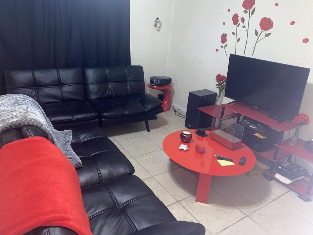 - un salon avec un canapé en cuir noir et une table rouge dans l'établissement Birdys Nest, à Las Vegas