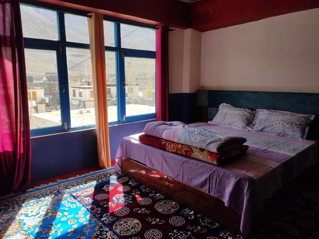 a bedroom with a bed and a large window at Nawang HomeStay in Kaza