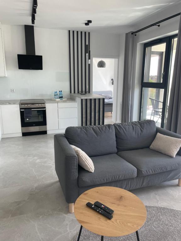 a living room with a couch and a table at Apartament Pendereckiego in Suwałki