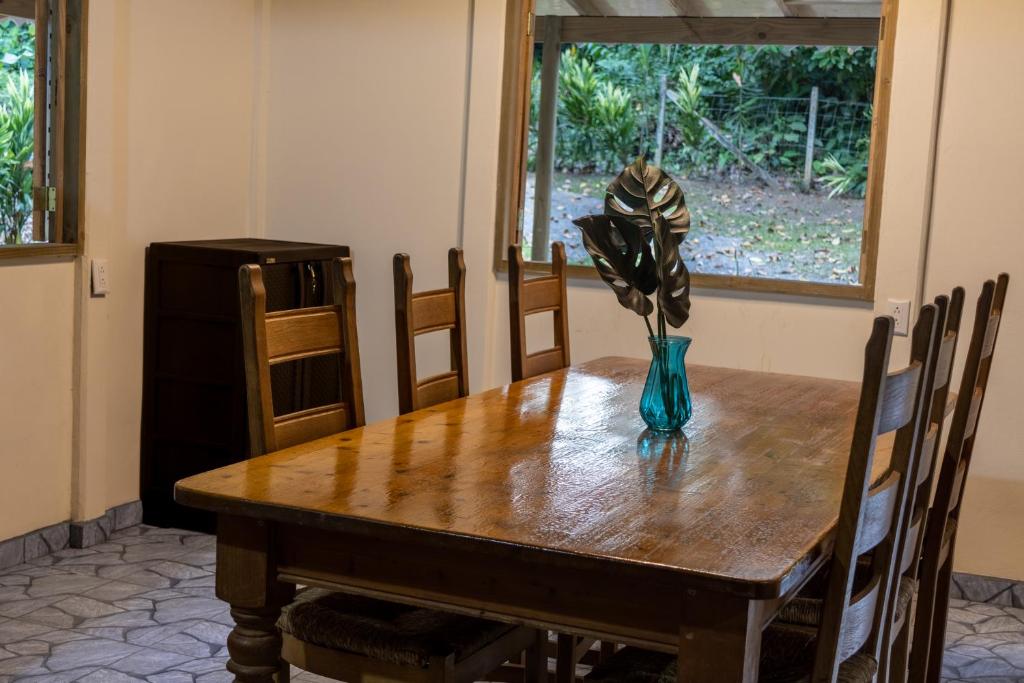 una mesa de comedor con un jarrón de flores. en Casa Siri de Cahuita en Cahuita