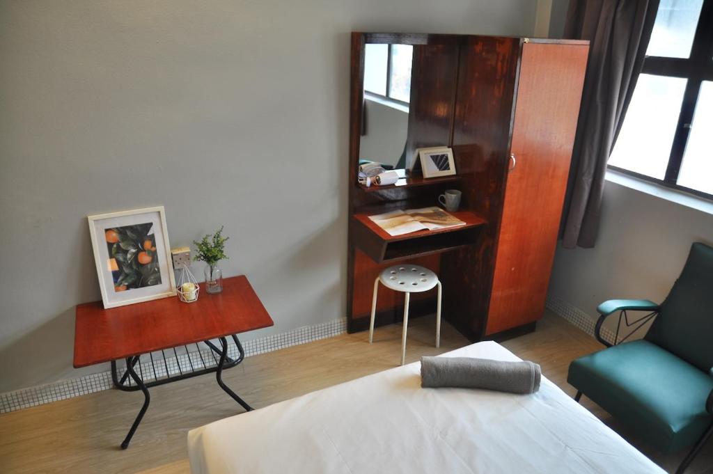 怡保的住宿－GRAYHAUS INN Ipoh，一间卧室配有书桌、一张床和一把椅子