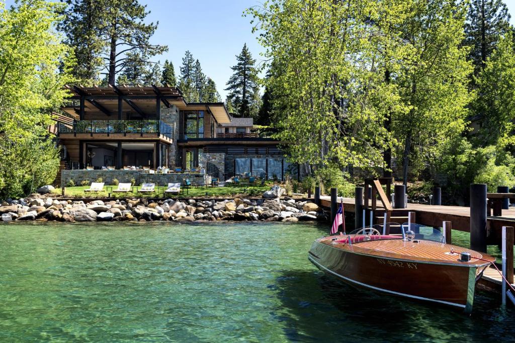 a house on the water with a boat in front of it at The Ritz-Carlton, Lake Tahoe in Truckee