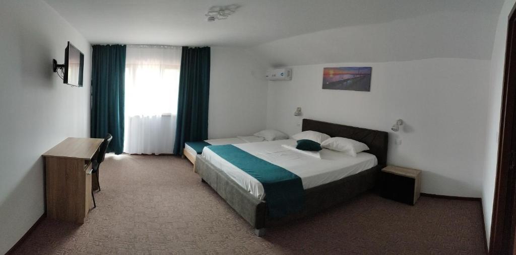 een hotelkamer met 2 bedden en een raam bij REMINA in Sulina