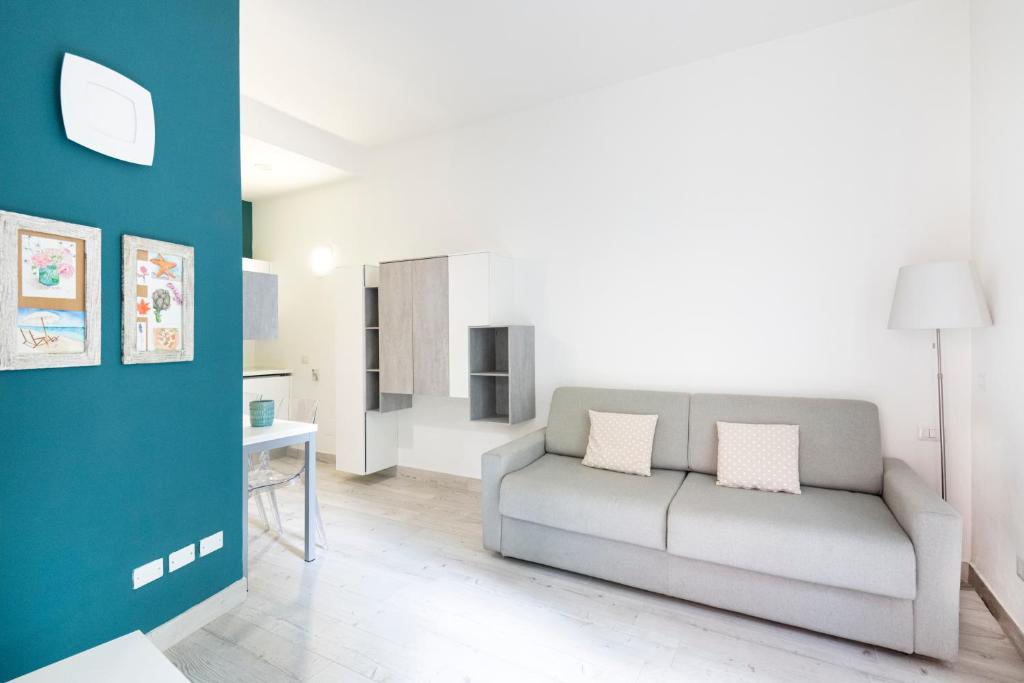 ein Wohnzimmer mit einem Sofa und einer Küche in der Unterkunft Easylife - Comodo Studio in Corso di Porta Romana in Mailand