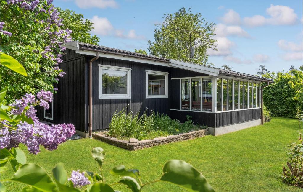 uma casa negra com um jardim em frente em Stunning Home In Bog By With Kitchen em Bogø By