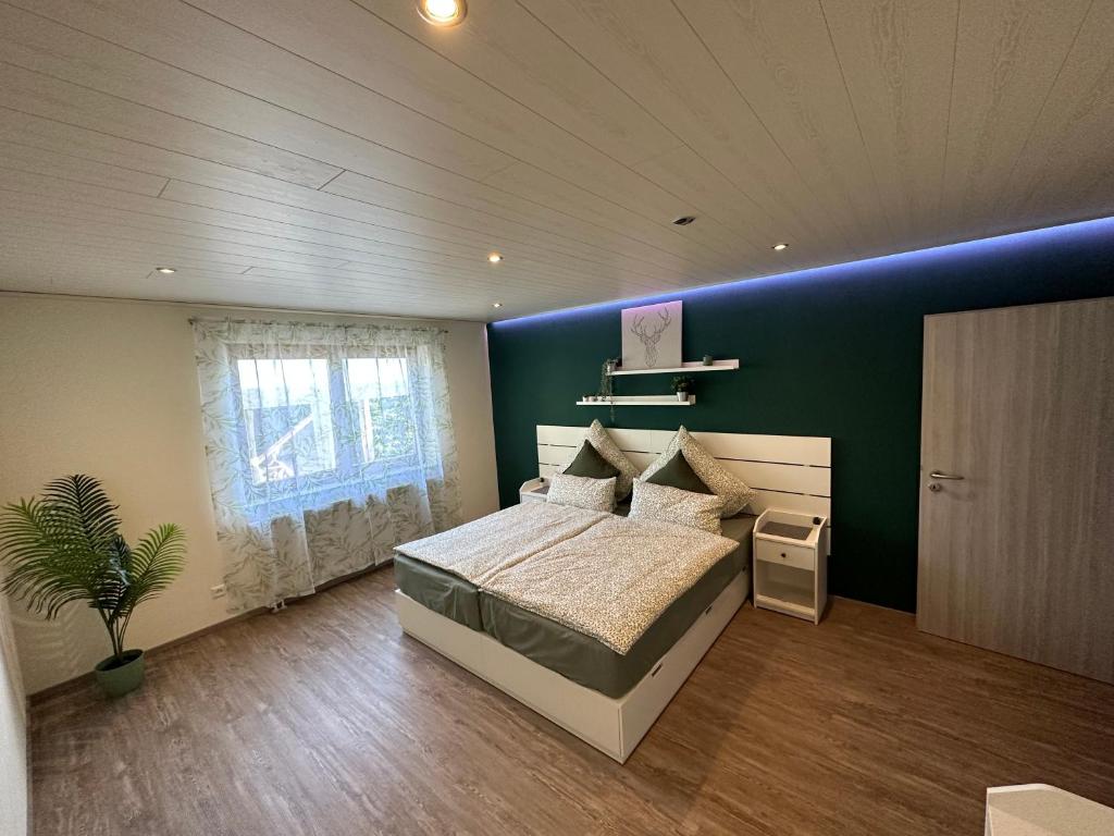 1 dormitorio con cama y pared azul en Bähnleblick Blumberg en Blumberg
