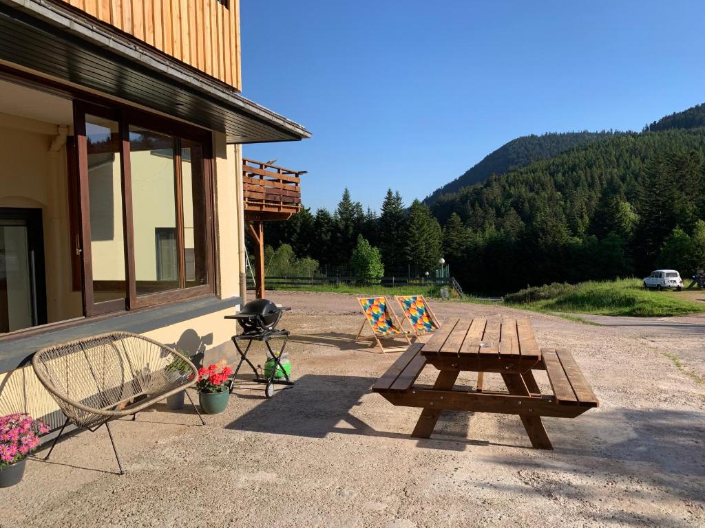 a picnic table and chairs sitting outside of a building at Le Perchoir- Grand Valtin 6 pers in Ban-sur-Meurthe-Clefcy