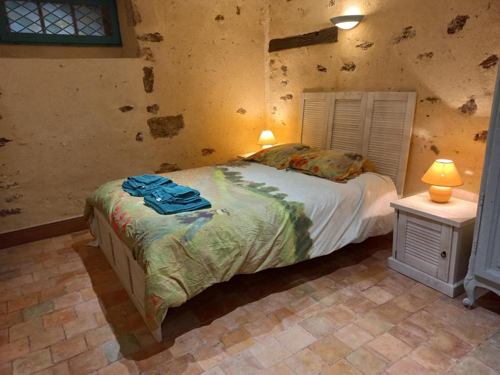 1 dormitorio con 1 cama y 1 mesa con lámpara en Chambre d'hôtes à proximité du circuit des 24h, en Ruaudin