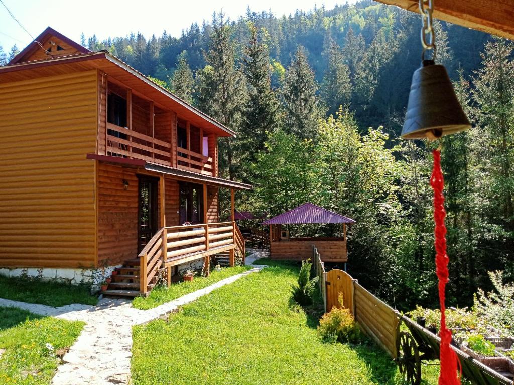 a log cabin with a bell on the side of it at Садиба На скелі in Krivorovnya