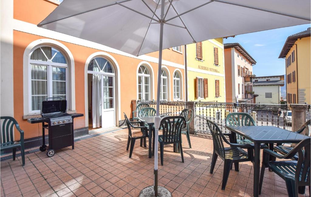 een patio met een tafel en stoelen en een parasol bij 3 Bedroom Stunning Apartment In Roncegno Terme in Marter di Roncegno