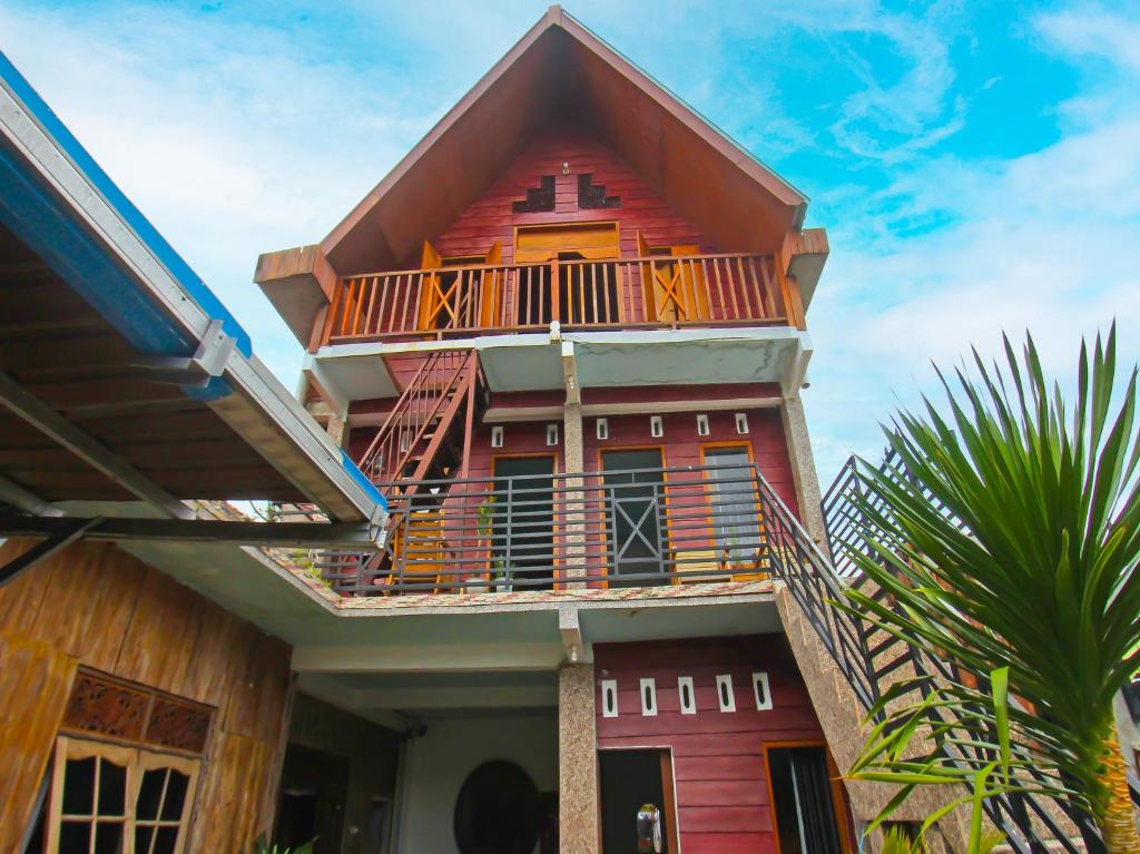 a building with a balcony on top of it at OYO 92558 Bale Datu Homestay in Montongbuwoh