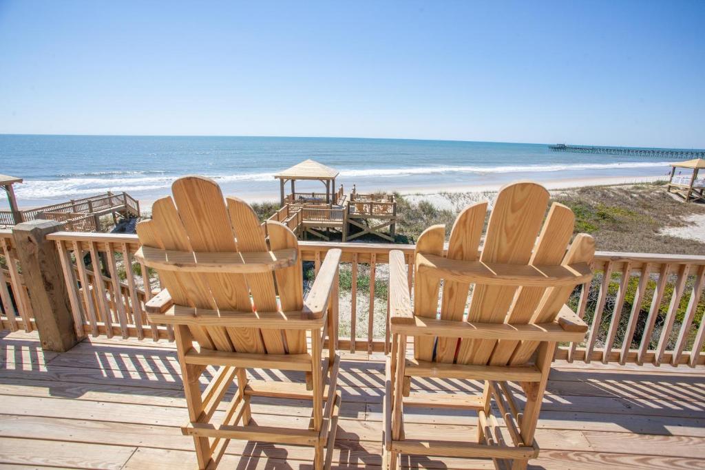 twee stoelen op een terras met uitzicht op het strand bij Gray Dolphin III in North Topsail Beach