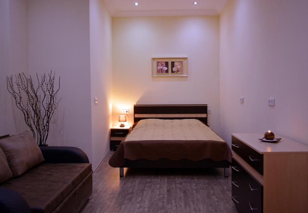 1 dormitorio con 1 cama y 1 sofá en Sayat Nova Apartments, en Tiflis