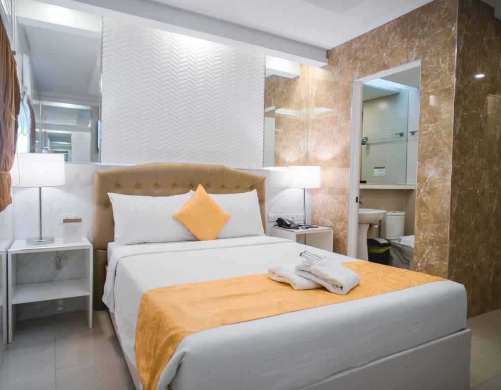 um quarto com uma cama com duas toalhas em Manila Grand Opera Hotel em Manila